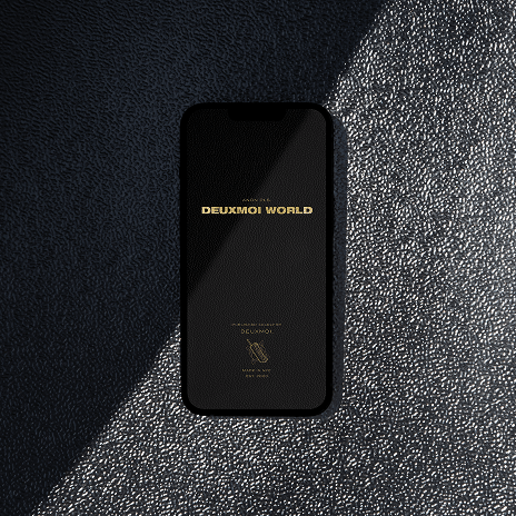 Phone with Deuxmoi World splash screen on textured black surface