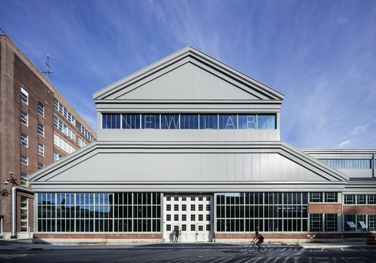 Newlab building exterior with large windows and cyclist on the street