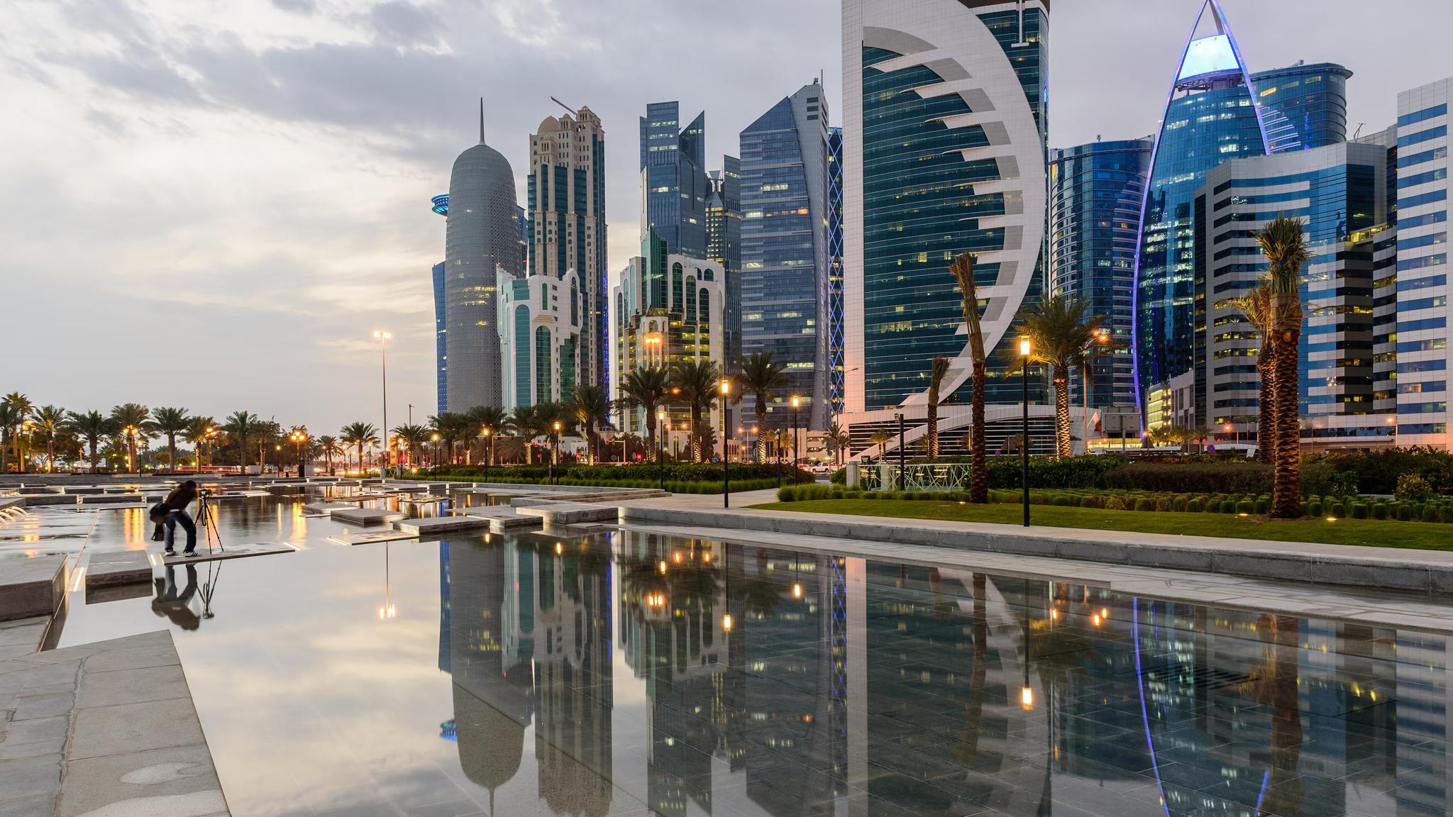 Modern Doha skyline reflected in water at dusk