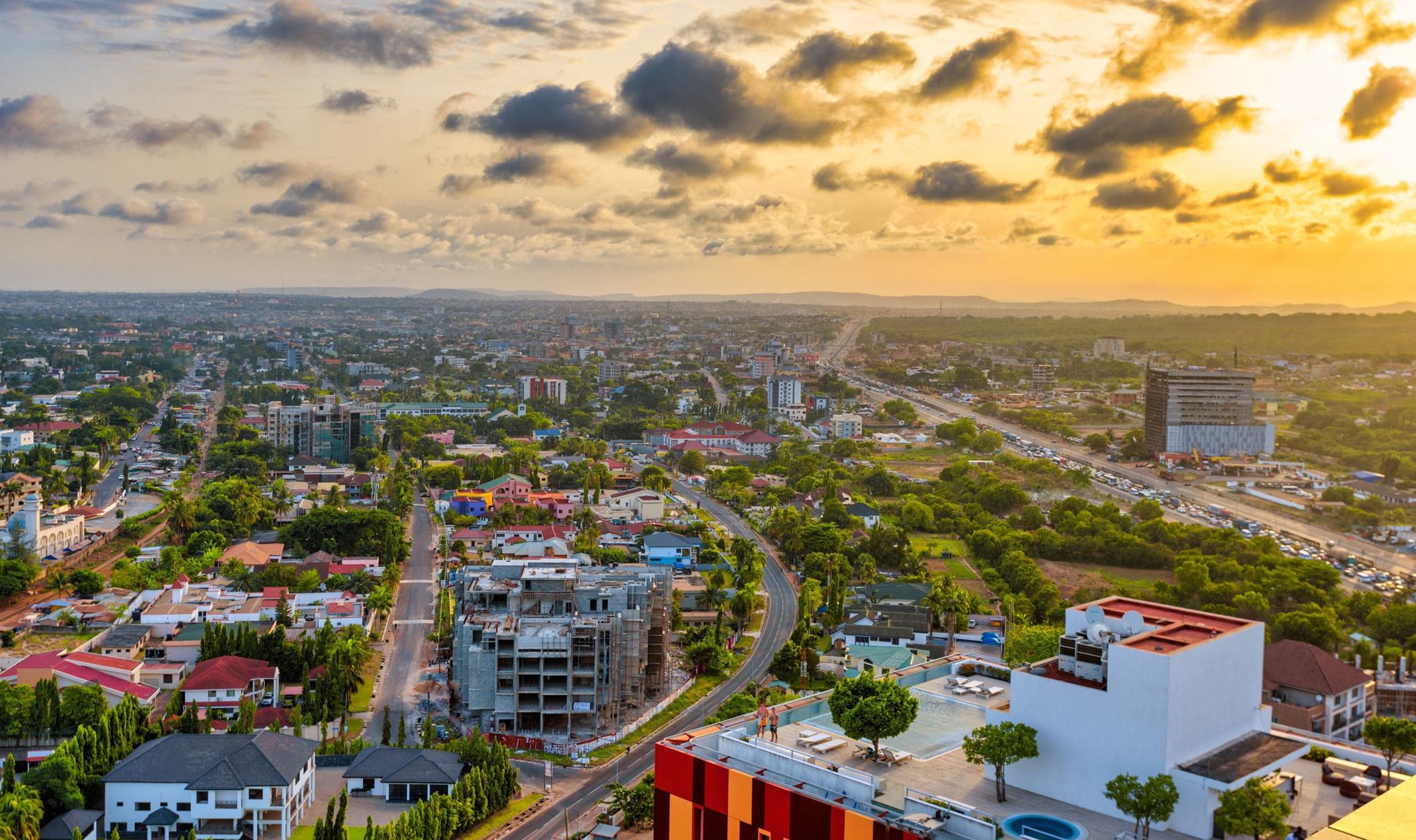 Aerial city skyline at sunset with roads and buildings