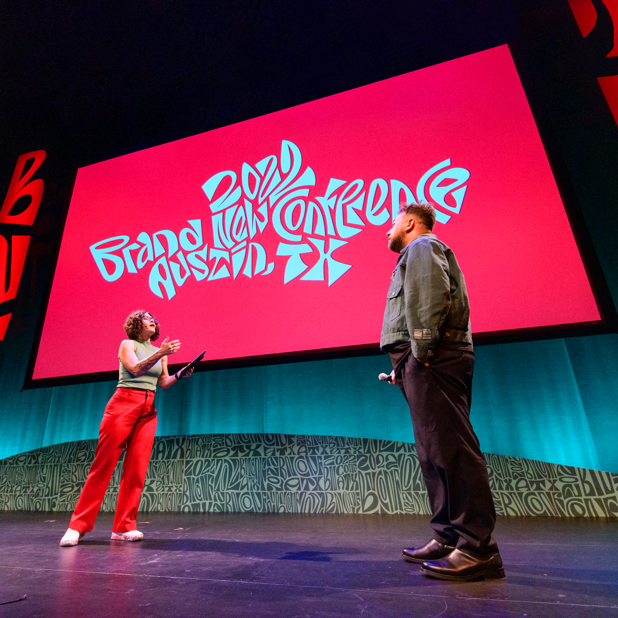Two speakers on stage beneath a 2022 Brand New Conference screen