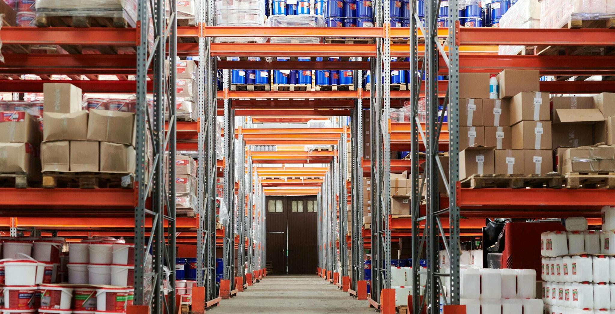 Tall warehouse aisles with shelves of boxes and supplies