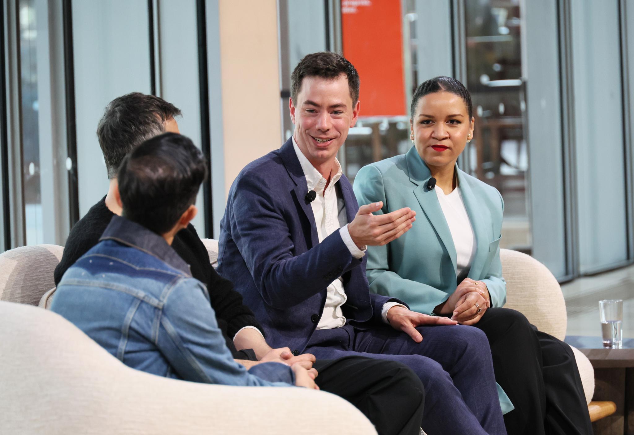 Four panelists in conversation on low armchairs at the BoF Professional Summit