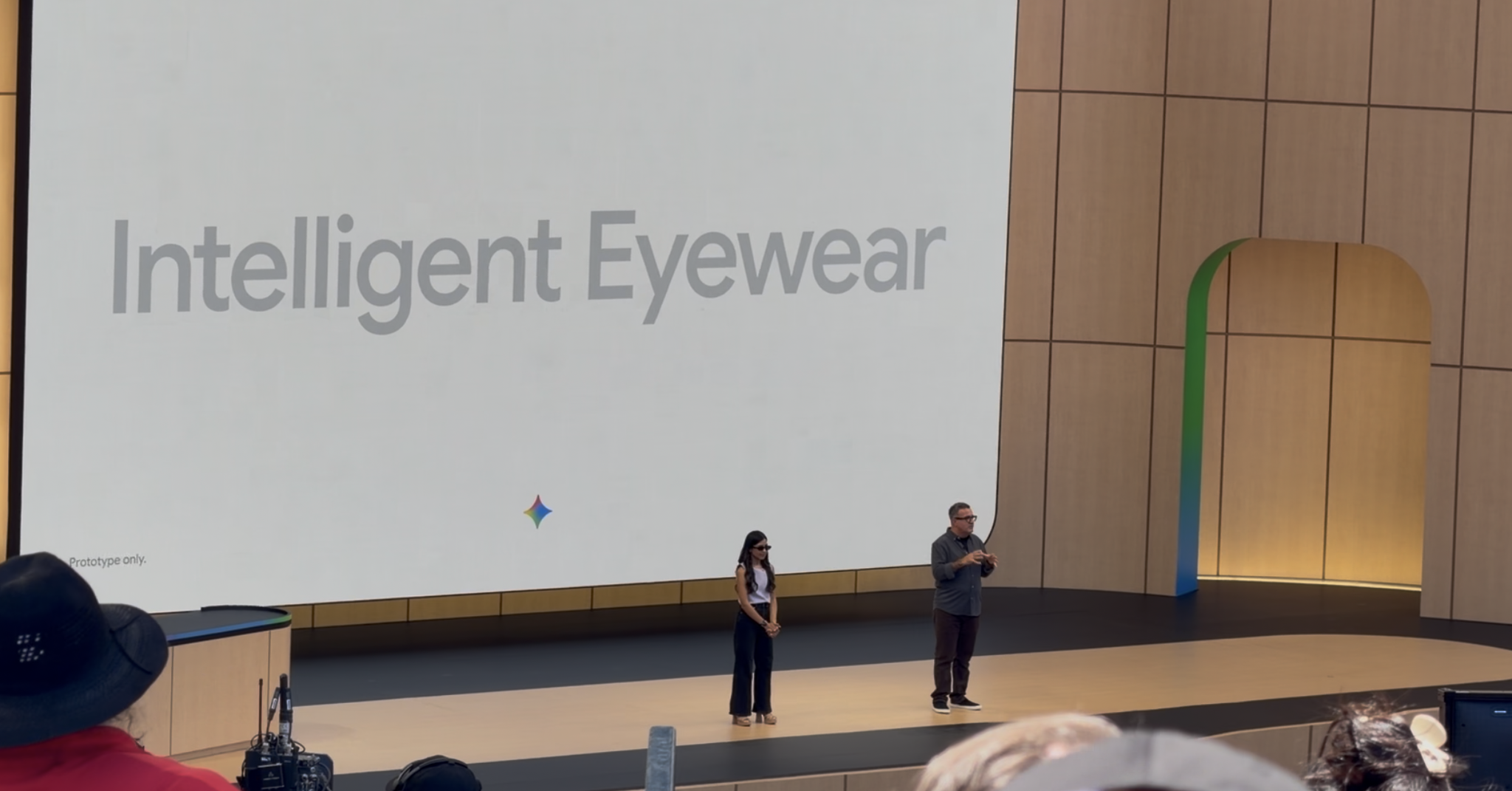 Conference stage screen displaying the words Intelligent Eyewear
