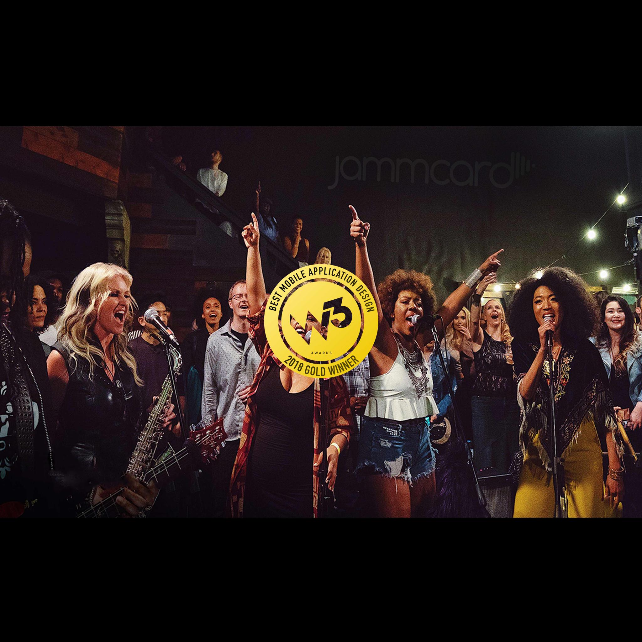 Musicians performing under a Jammcard backdrop with a W3 2018 Gold Winner badge overlaid