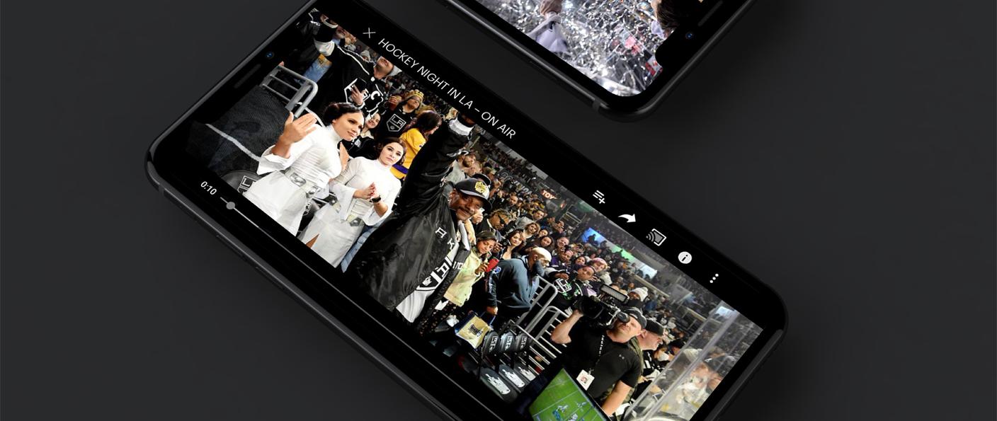 Two phones on a dark surface playing Hockey Night in LA arena videos