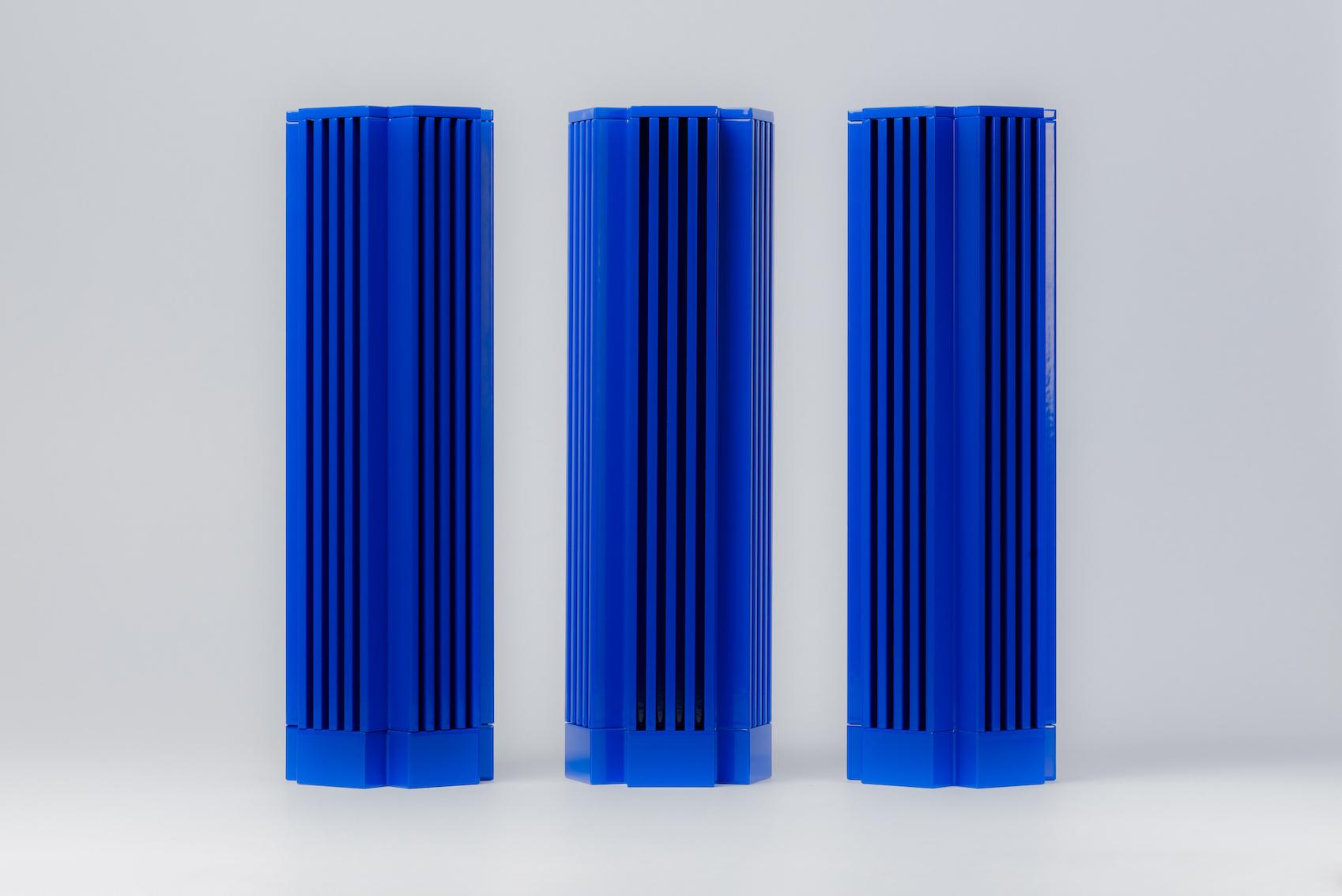 Three tall blue ribbed rectangular objects on a light gray background
