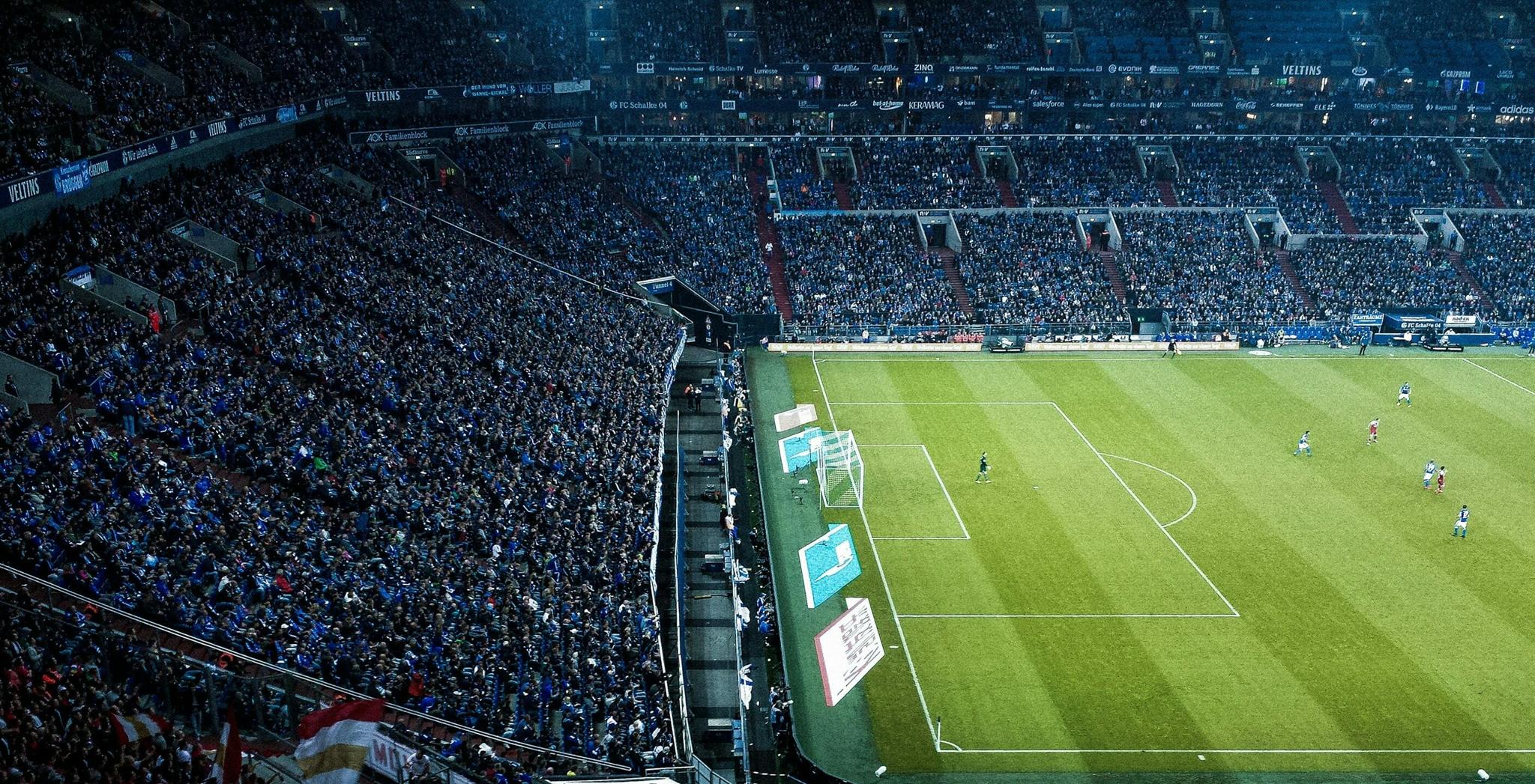Packed soccer stadium viewed from above during a match