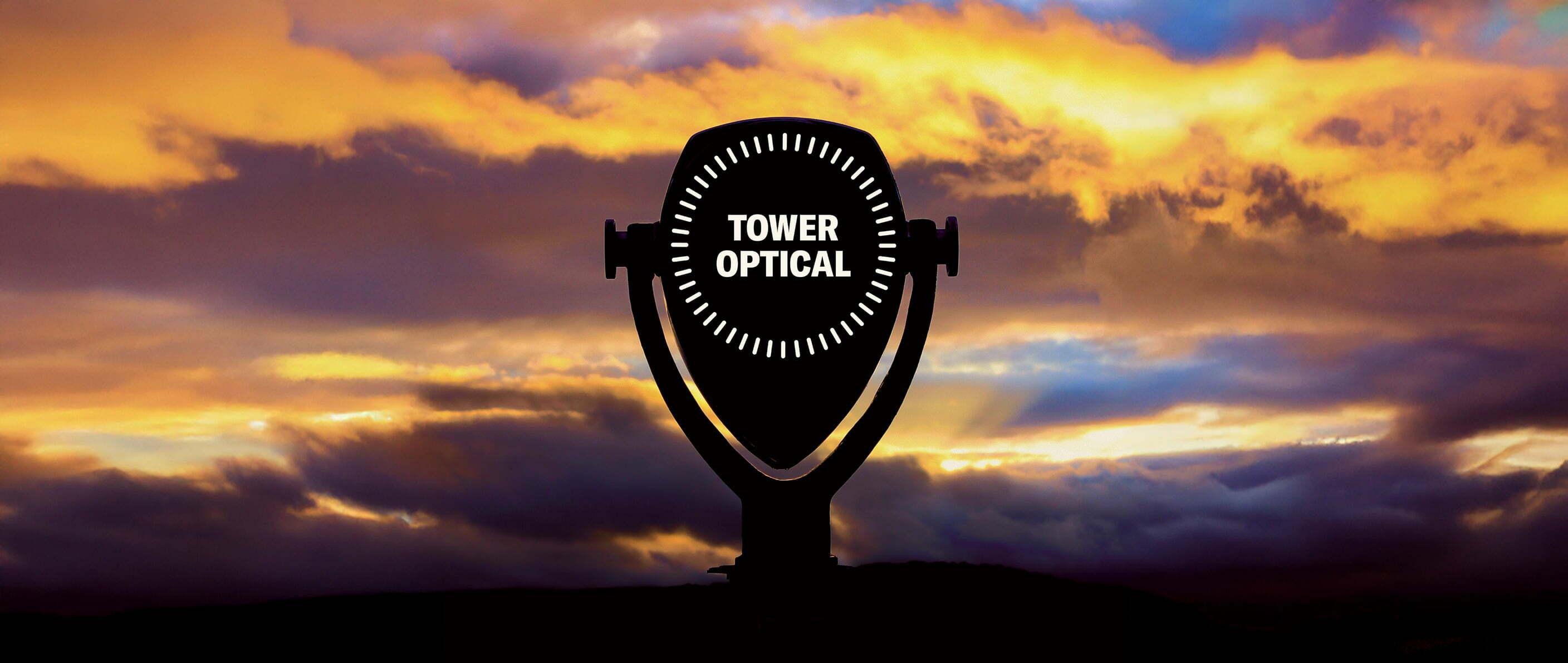 Tower Optical coin-operated viewer silhouetted against a sunset sky