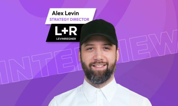 Bearded man in black cap on a purple interview graphic with L+R branding
