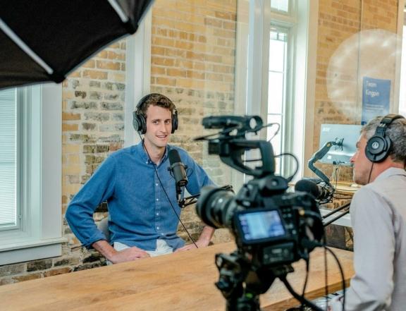 Podcast recording setup with microphones, headphones, and camera