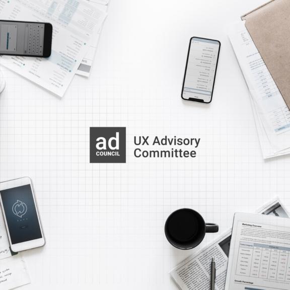 Ad Council UX Advisory Committee logo on a white desk with devices