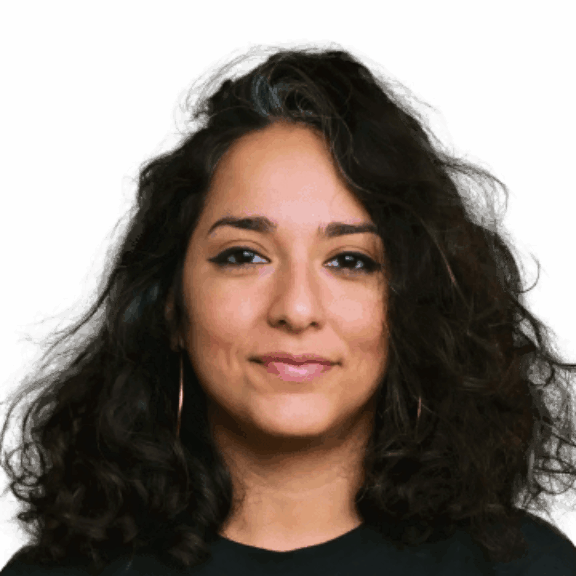 Woman with voluminous dark hair and hoop earrings on a green background