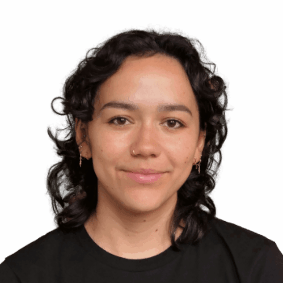 Woman with curly dark hair, earrings, and a black shirt on a green background