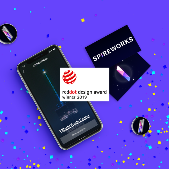 Spireworks phone mockup and Red Dot Design Award badge on purple confetti background