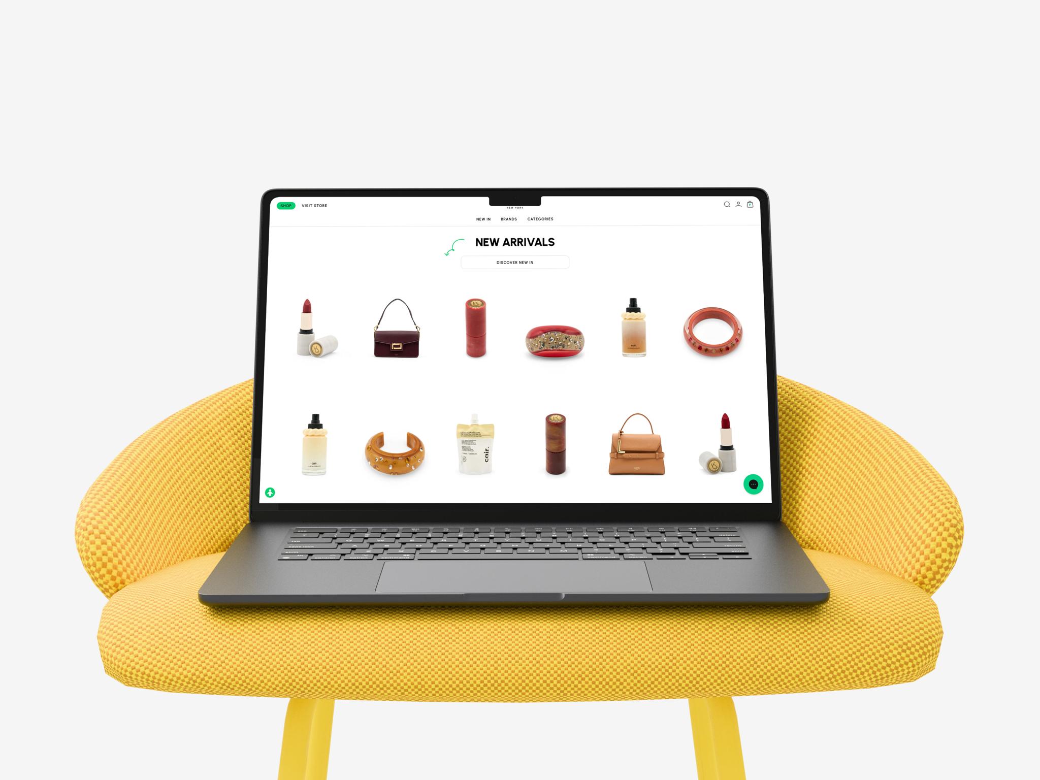 Laptop on a yellow chair showing Printemps new arrivals with beauty and fashion items
