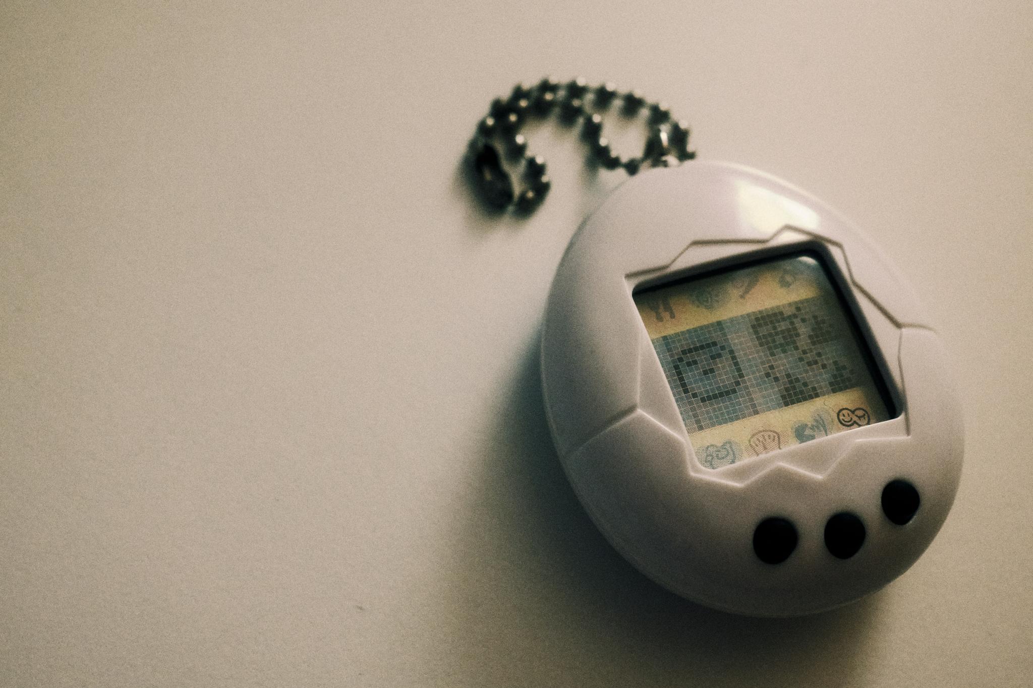 White egg-shaped virtual pet keychain with pixel screen