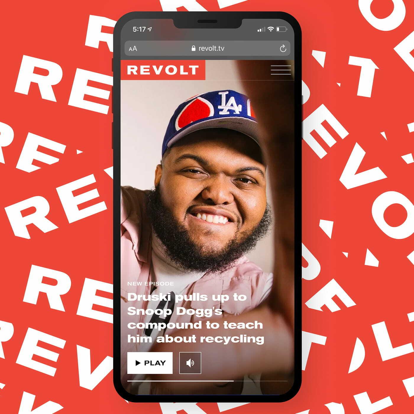 Smartphone showing REVOLT story about Druski on a red branded background