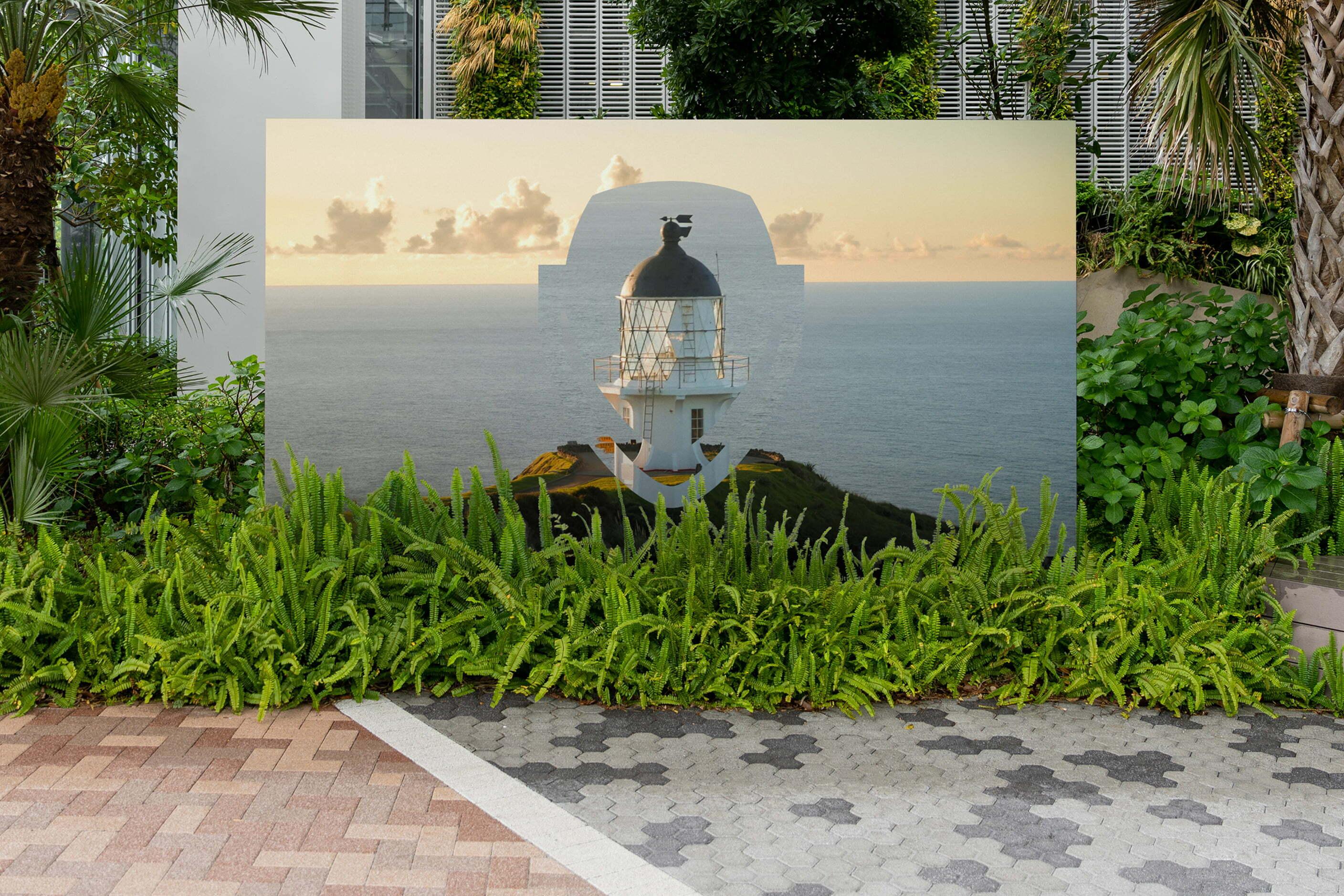 Outdoor sign with a Pinecone landscape graphic surrounded by greenery