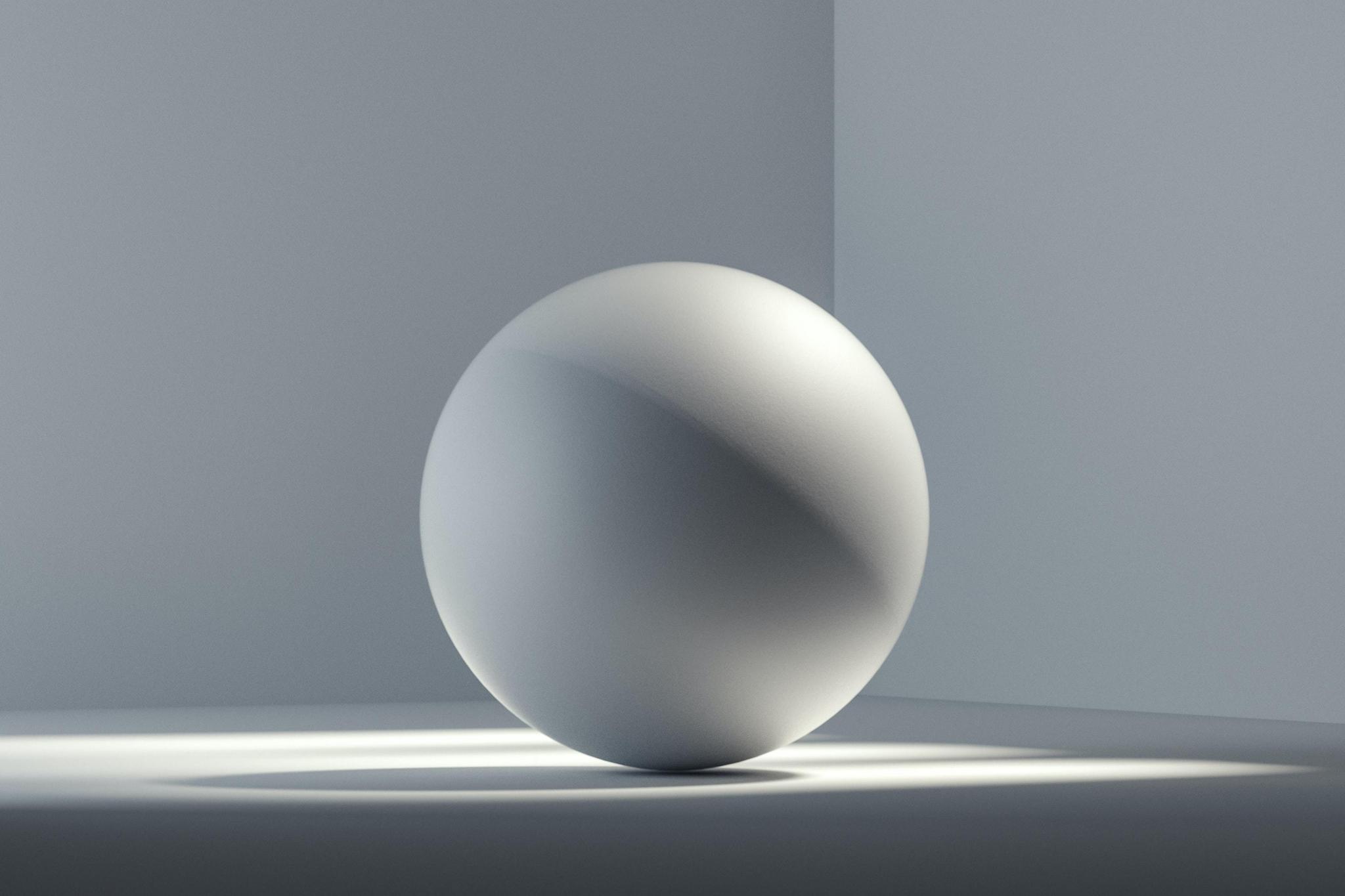 Matte sphere casting a shadow in a minimal gray corner
