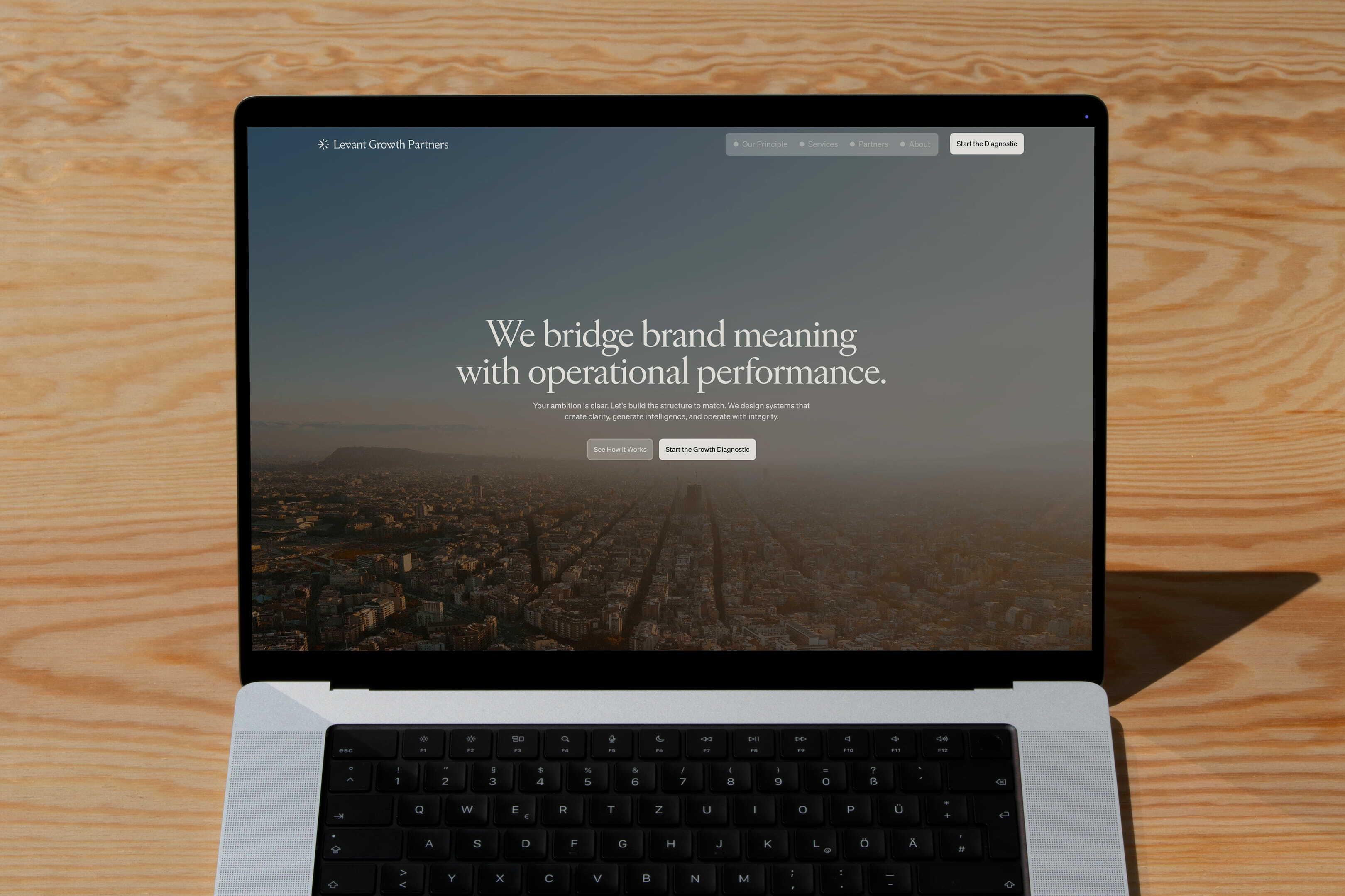 Laptop displaying the Levant Growth Partners homepage on a wooden table
