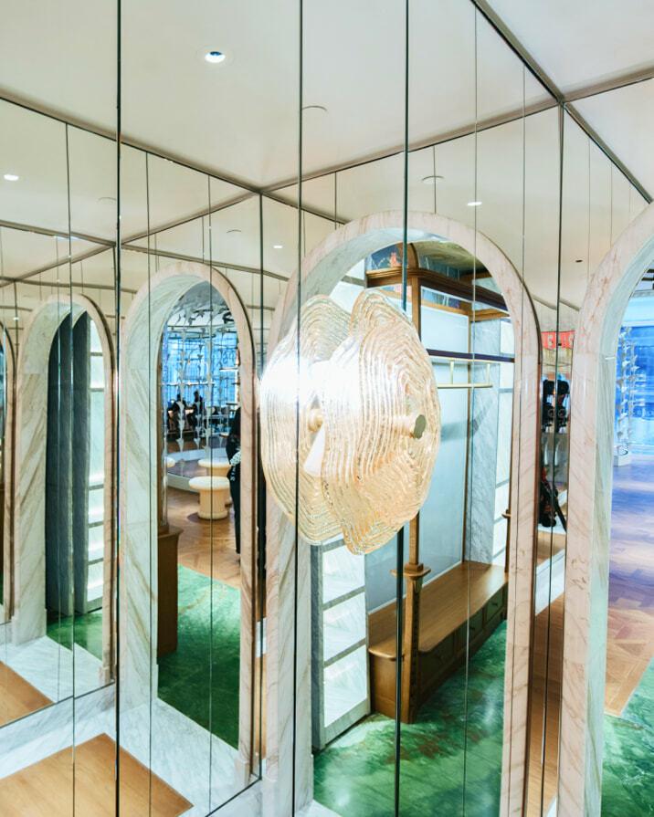 Mirrored corridor with arched openings and a glowing pendant light