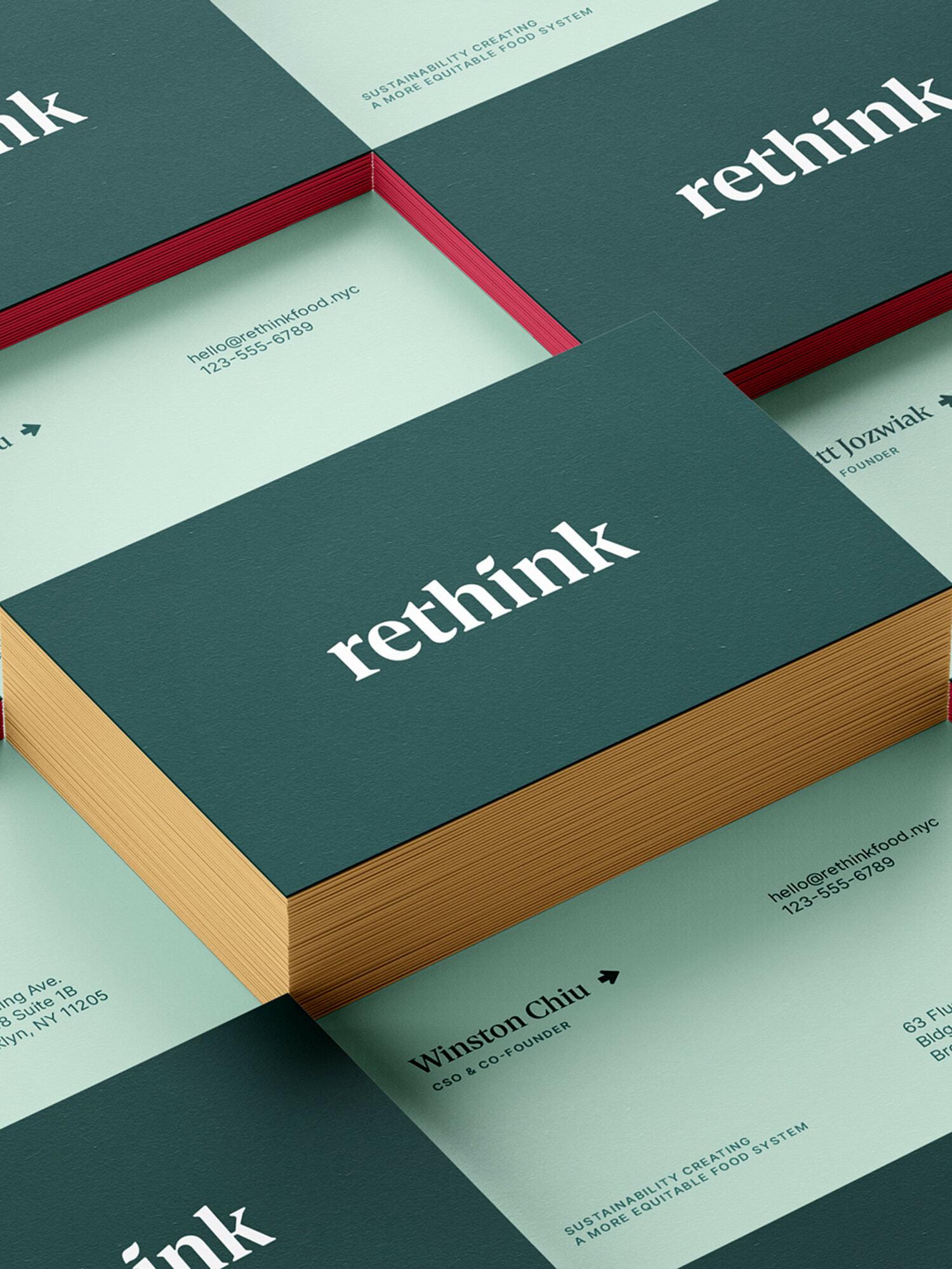 Stacks of teal business cards with "rethink" branding and gold edges on a pale green background