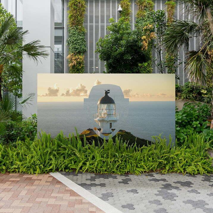 Outdoor sign with a Pinecone landscape graphic surrounded by greenery