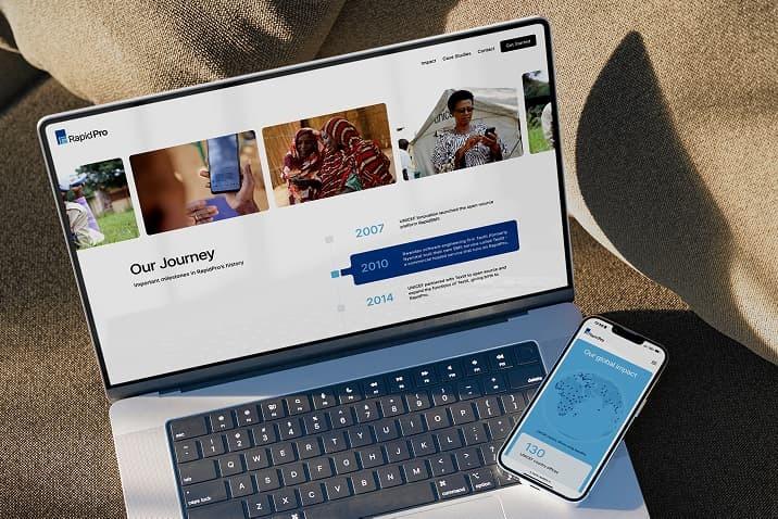 Laptop and phone displaying RapidPro pages on an outdoor cushion