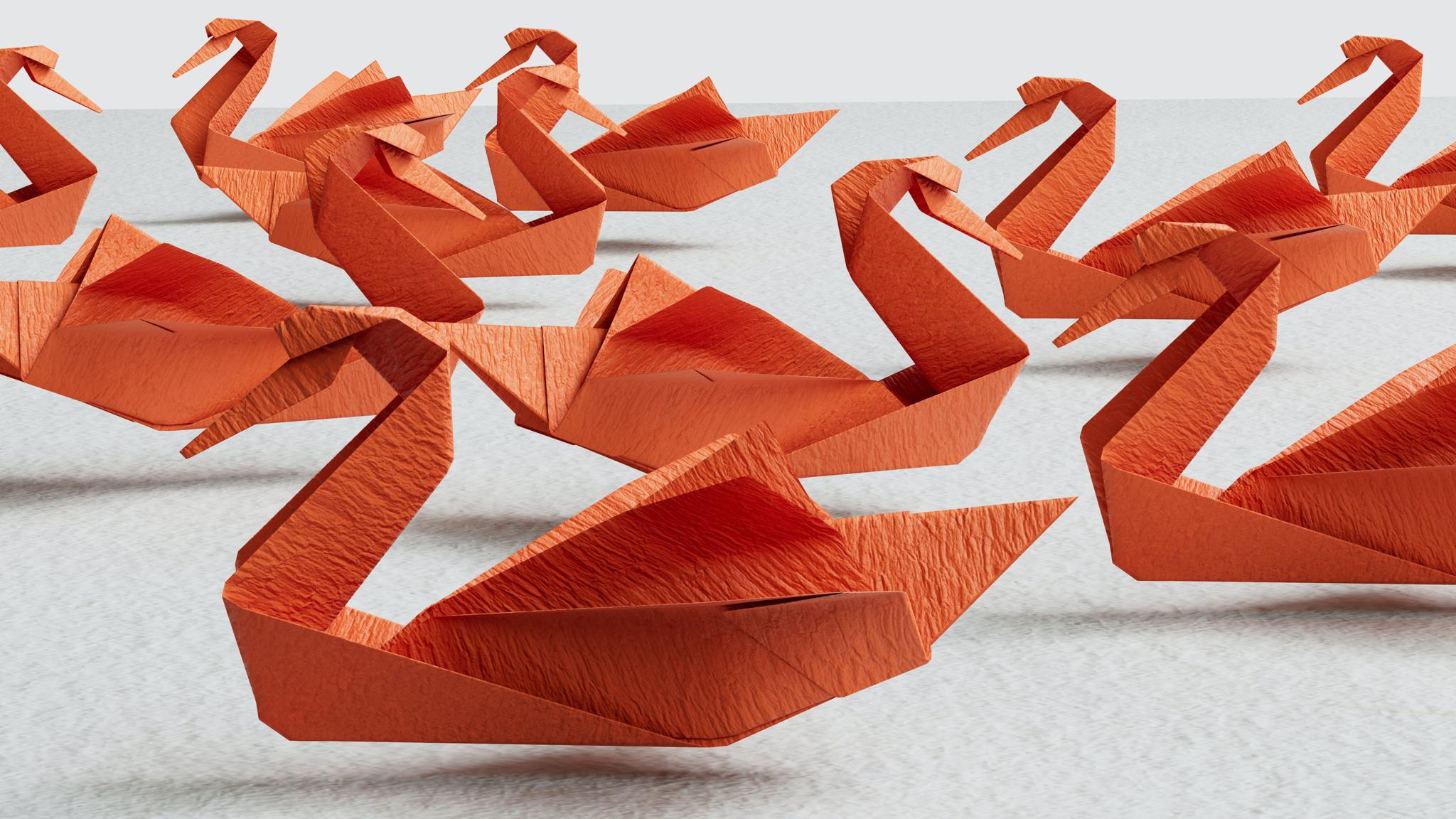 Several orange origami swans arranged on a light surface