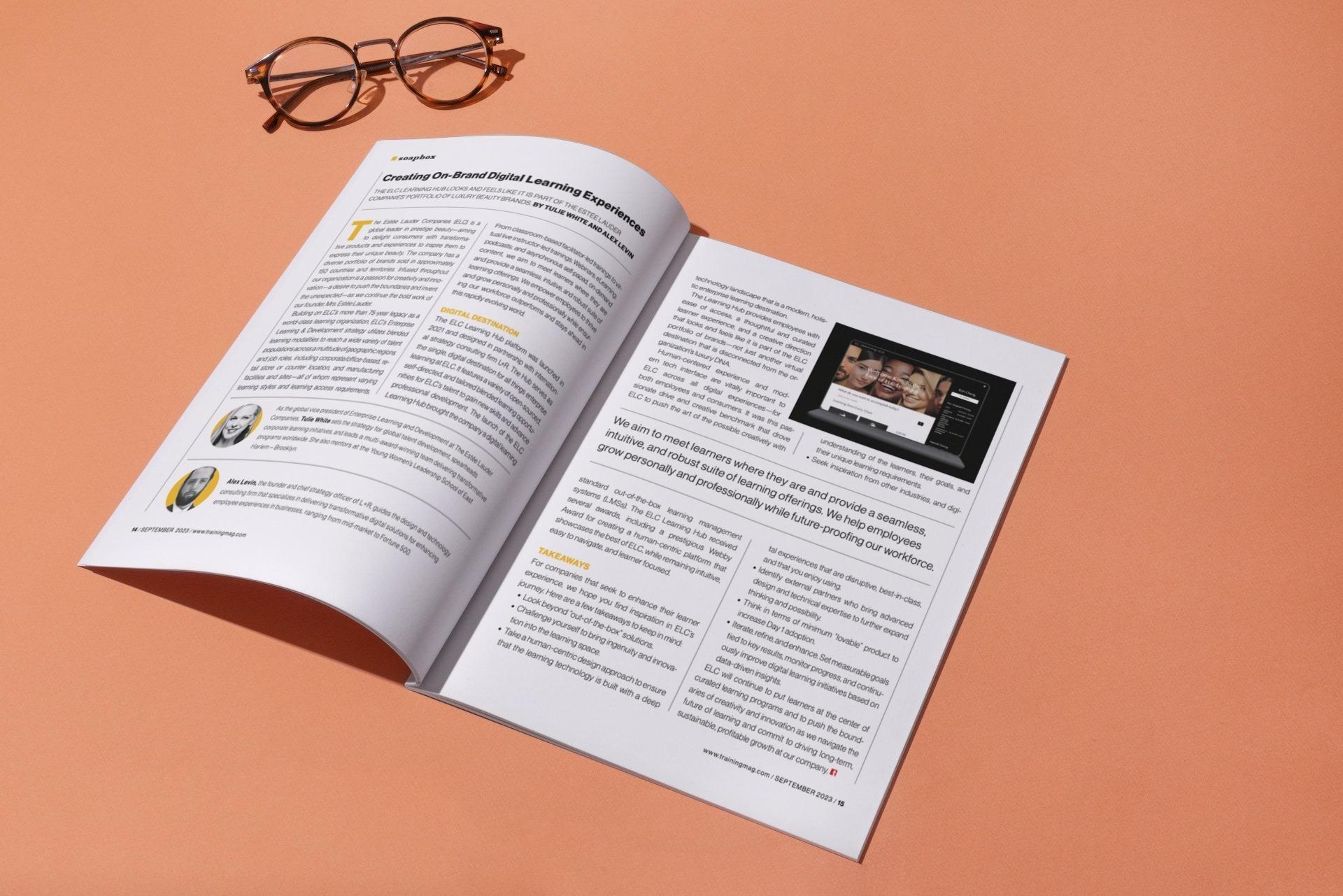 Open printed booklet with glasses on an orange surface