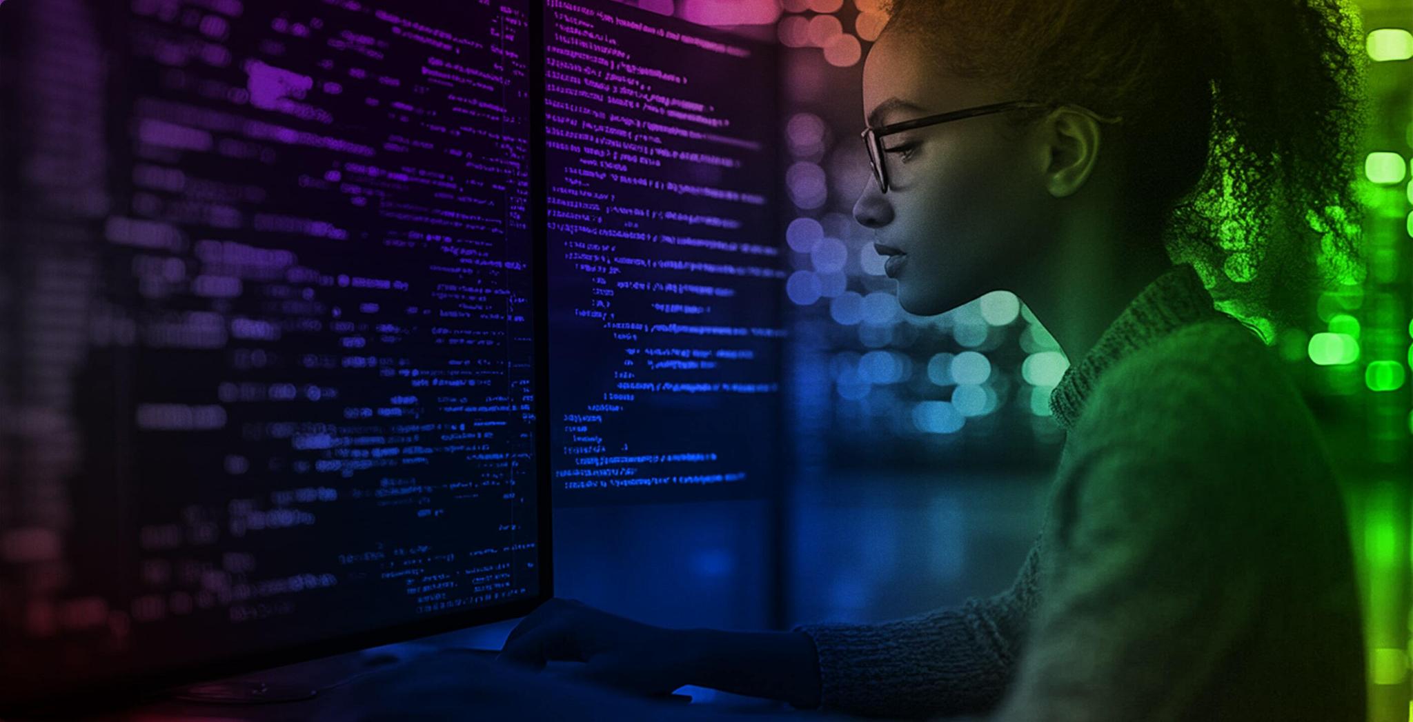 Person working at computer monitors filled with code
