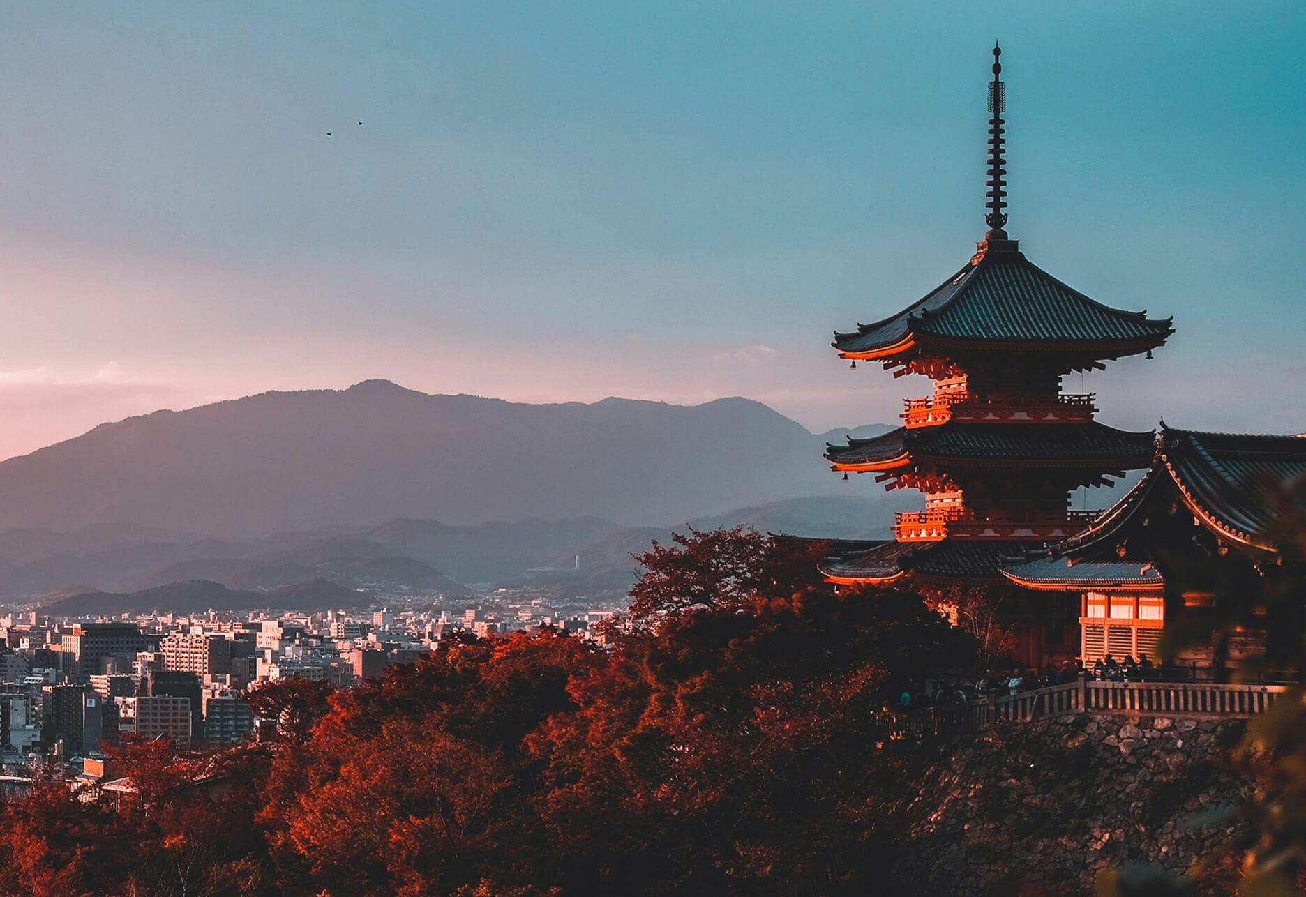 Pagoda overlooking Kyoto at sunset with mountains in the distance