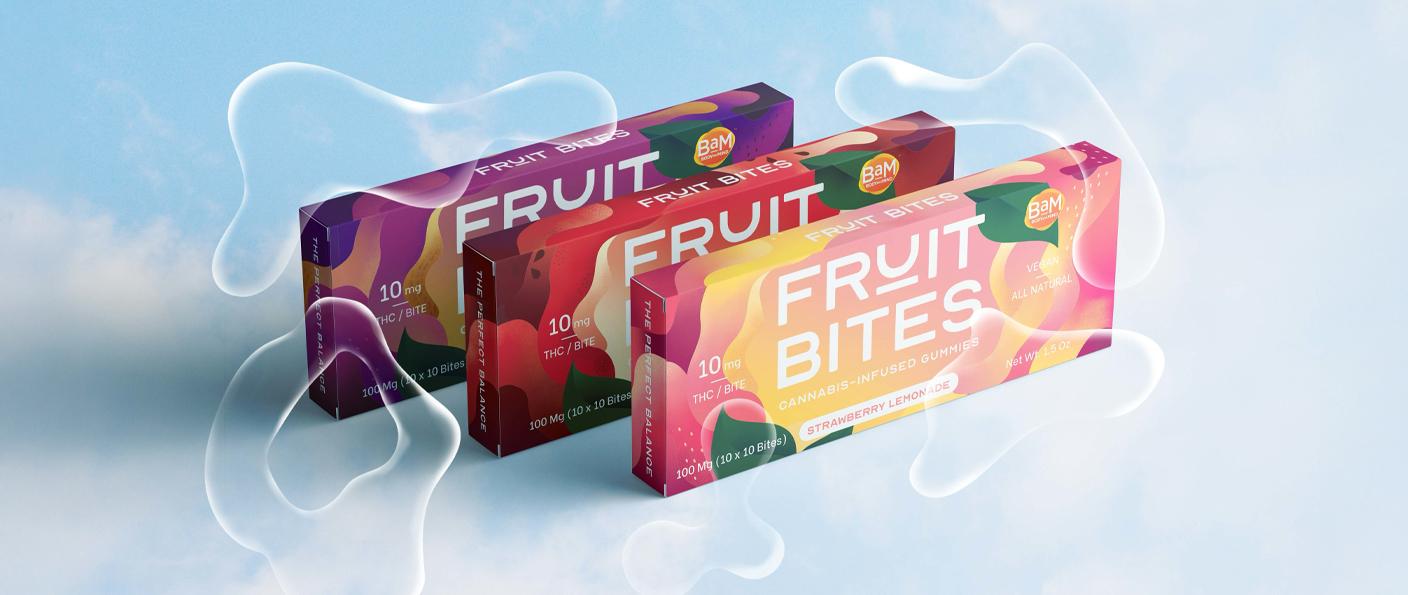 Three colorful Fruit Bites snack boxes on a soft blue background with white swirl accents