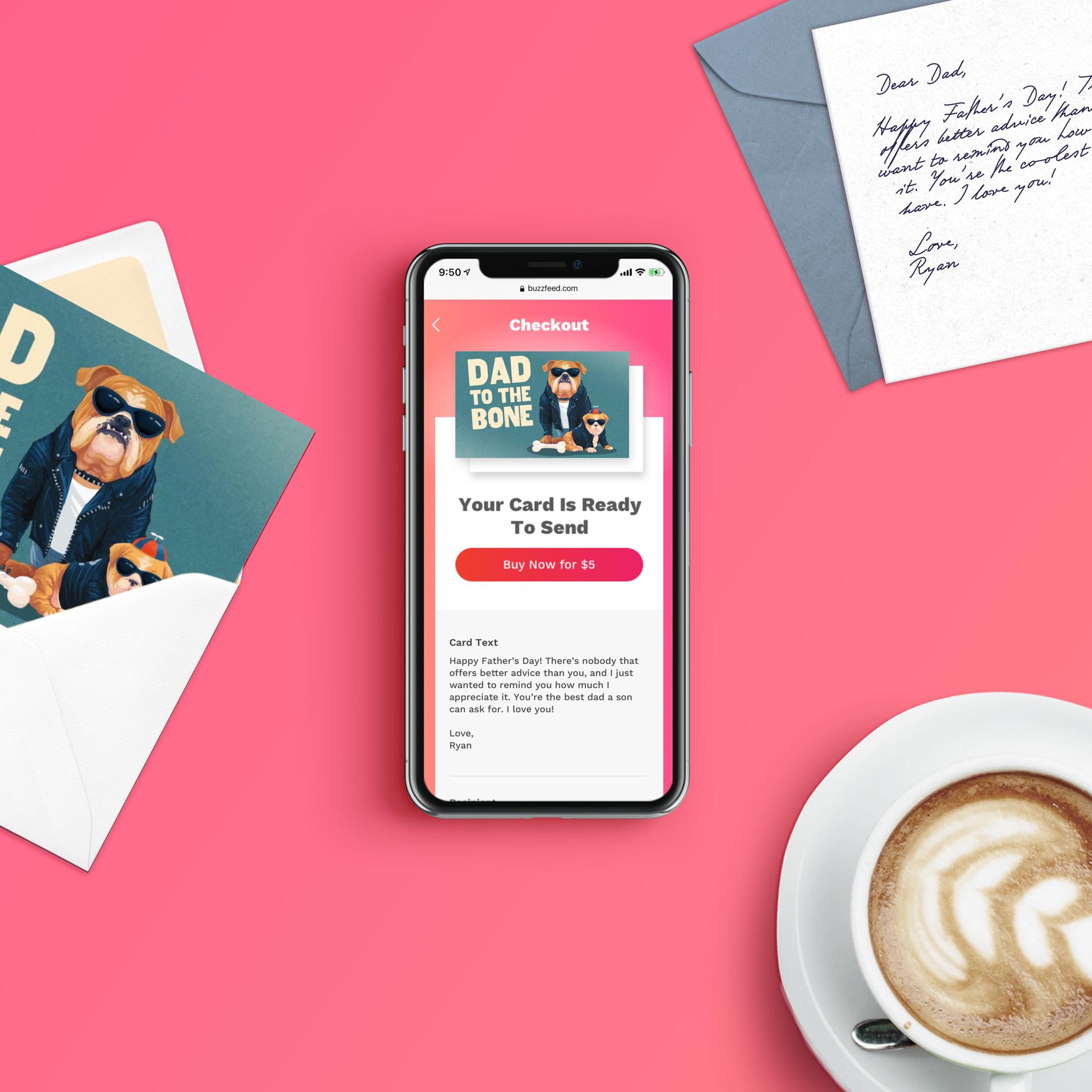 Phone showing greeting card checkout on a pink desk with card, handwritten note, and coffee
