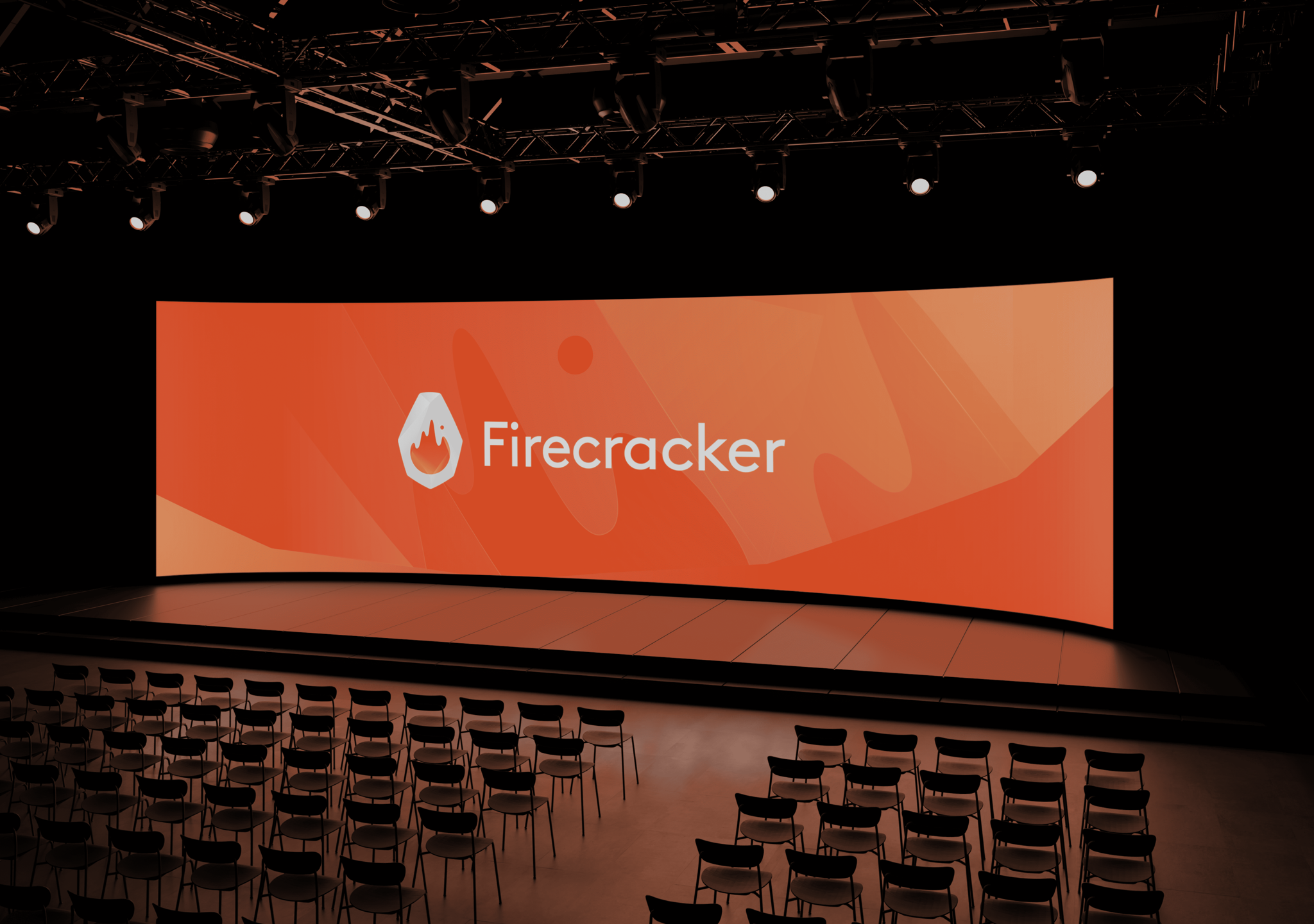 Auditorium stage with orange Firecracker logo presentation screen and rows of empty chairs