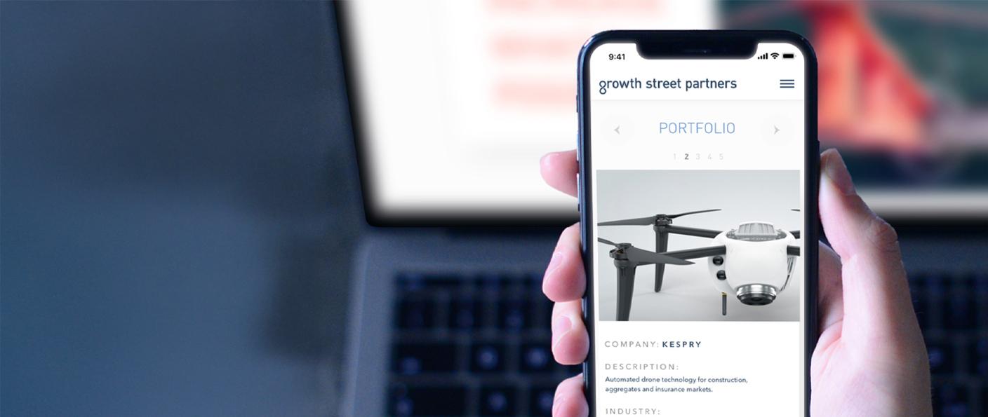 Hand holding phone showing a Growth Street Partners portfolio page
