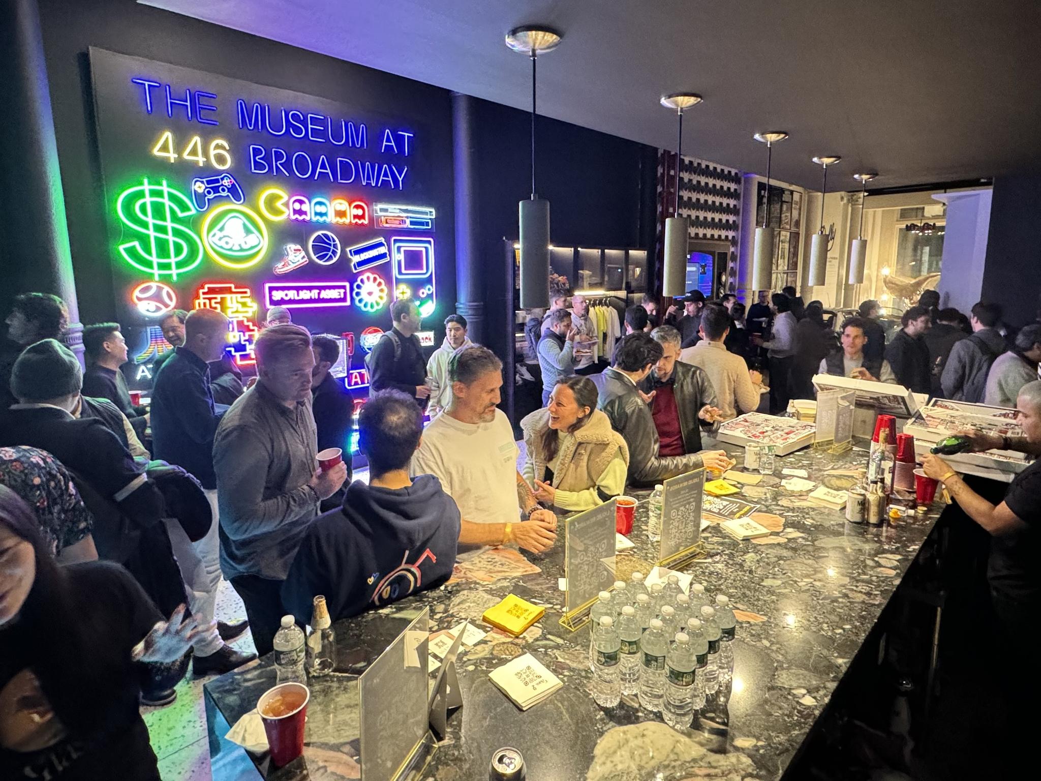 Crowded bar event under neon signs at The Museum at 446 Broadway