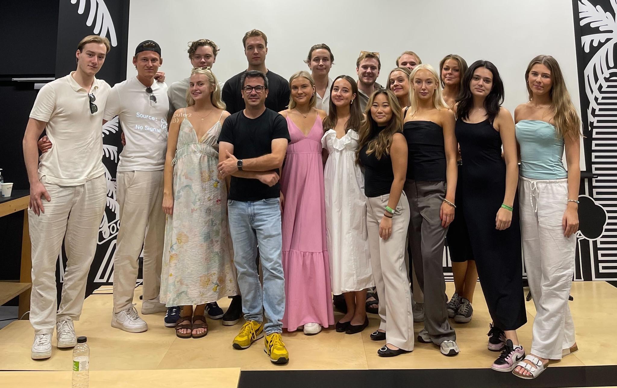 Group of young adults posing together in a room with black-and-white wall art