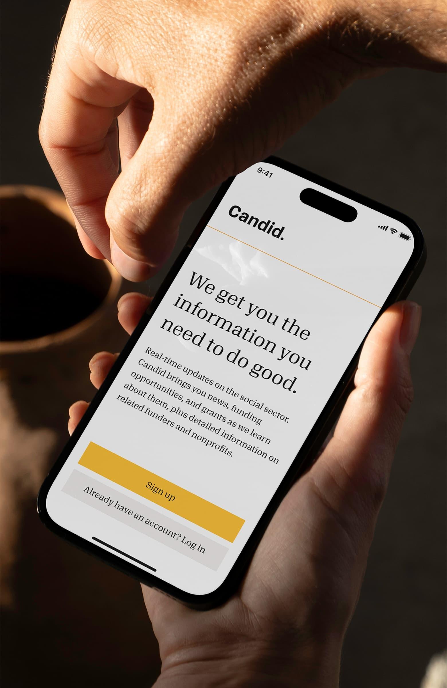 Hand holding a phone with the Candid sign-up page open