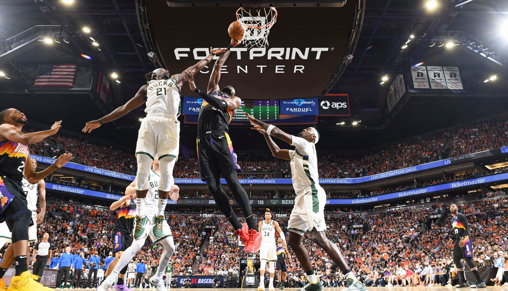 Players contest a shot at the rim during a packed game at Footprint Center