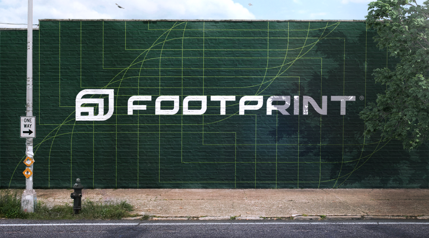 FOOTPRINT mural on a green wall beside a street