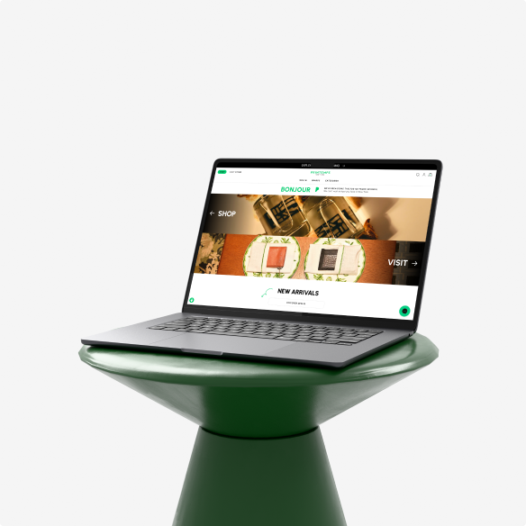 Laptop on a glossy green pedestal showing a Printemps homepage