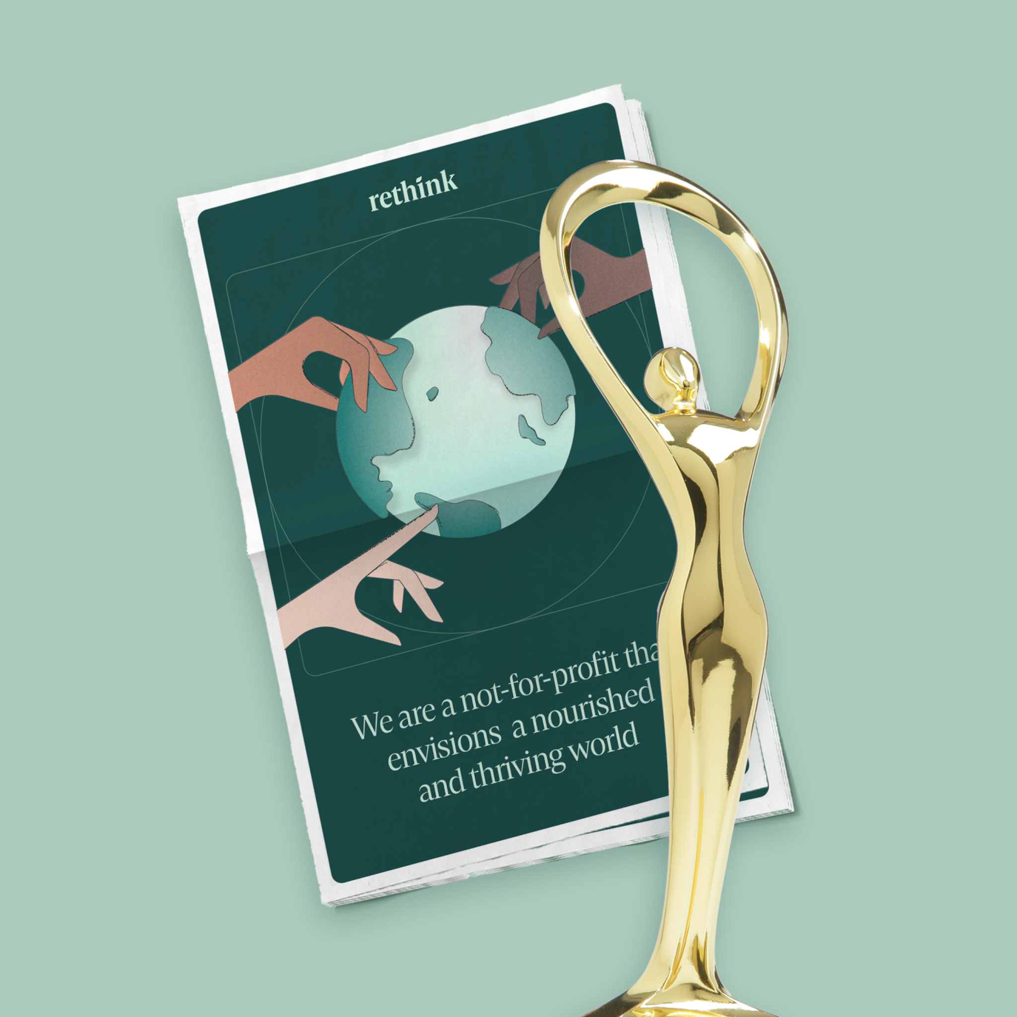 Gold trophy standing over a Rethink brochure on a pale green background.