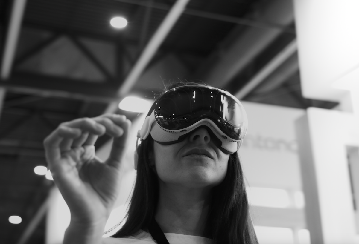 Person wearing a VR headset reaching forward in a blurred indoor setting