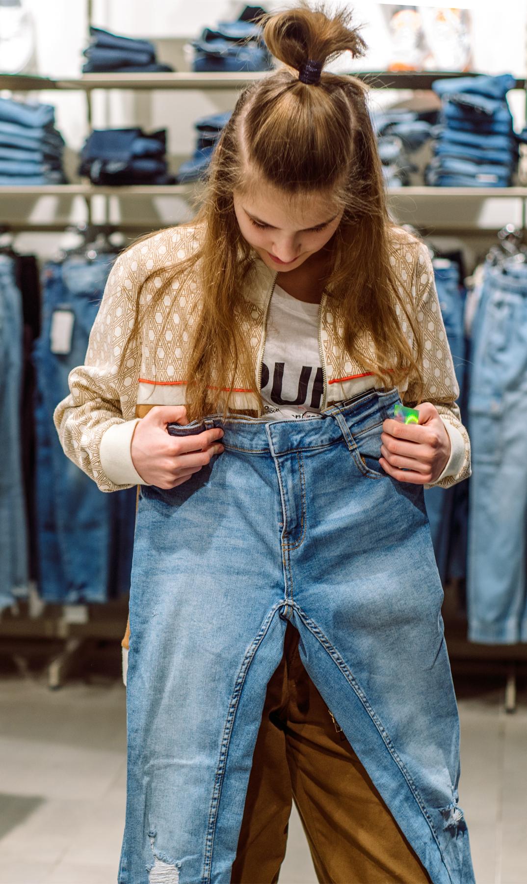 Shopper holding jeans in a denim store