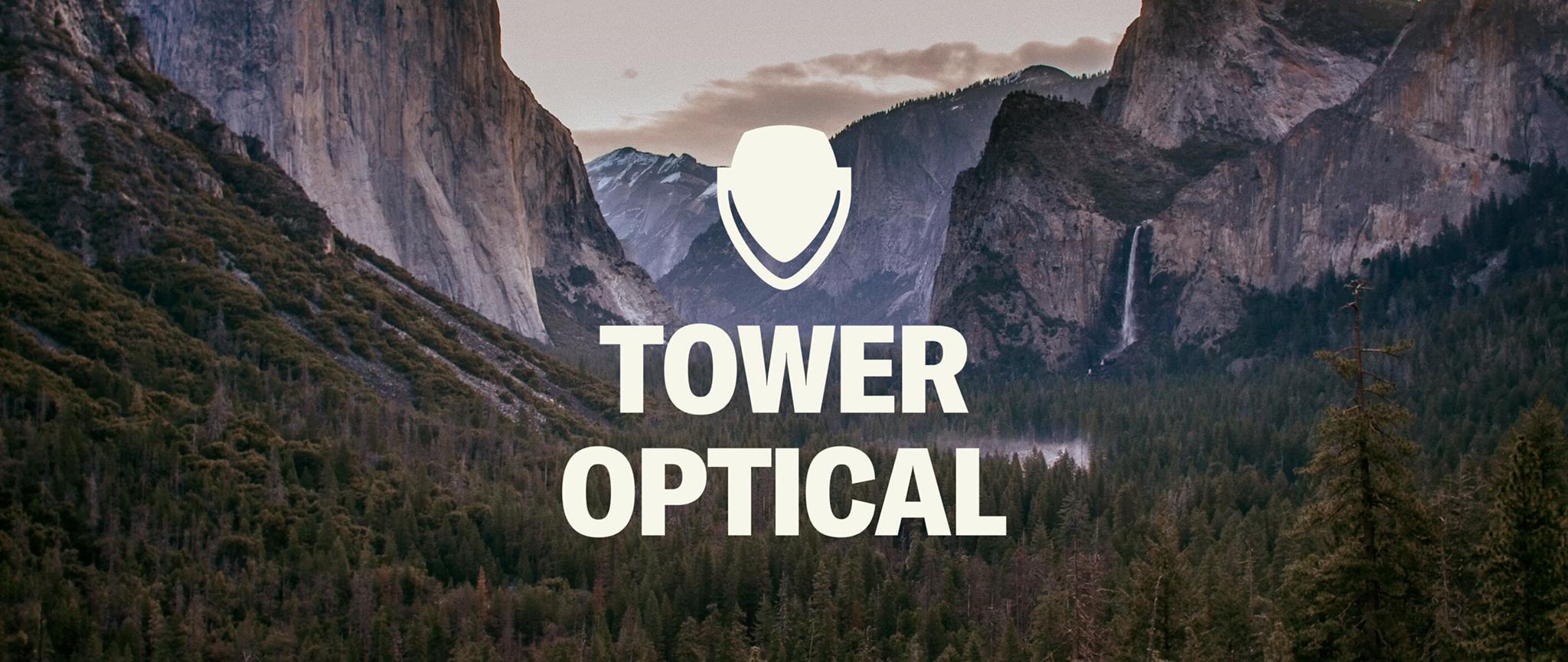 Tower Optical logo over a mountain valley landscape.
