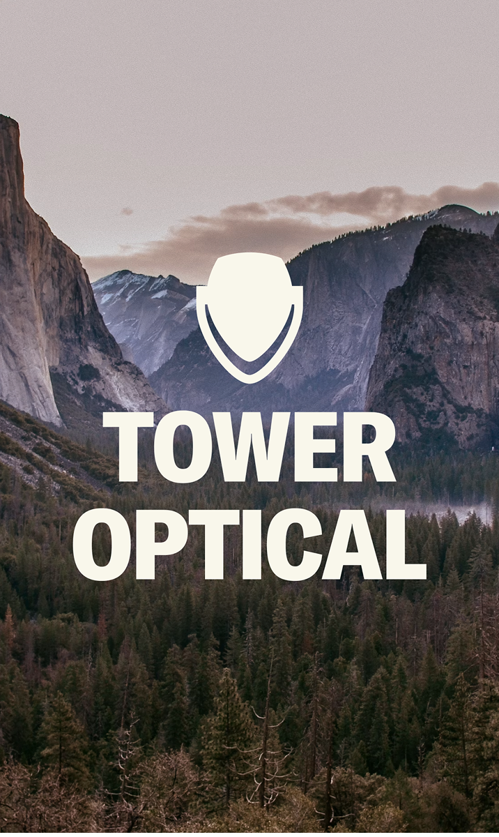 Tower Optical logo over a mountain valley landscape.