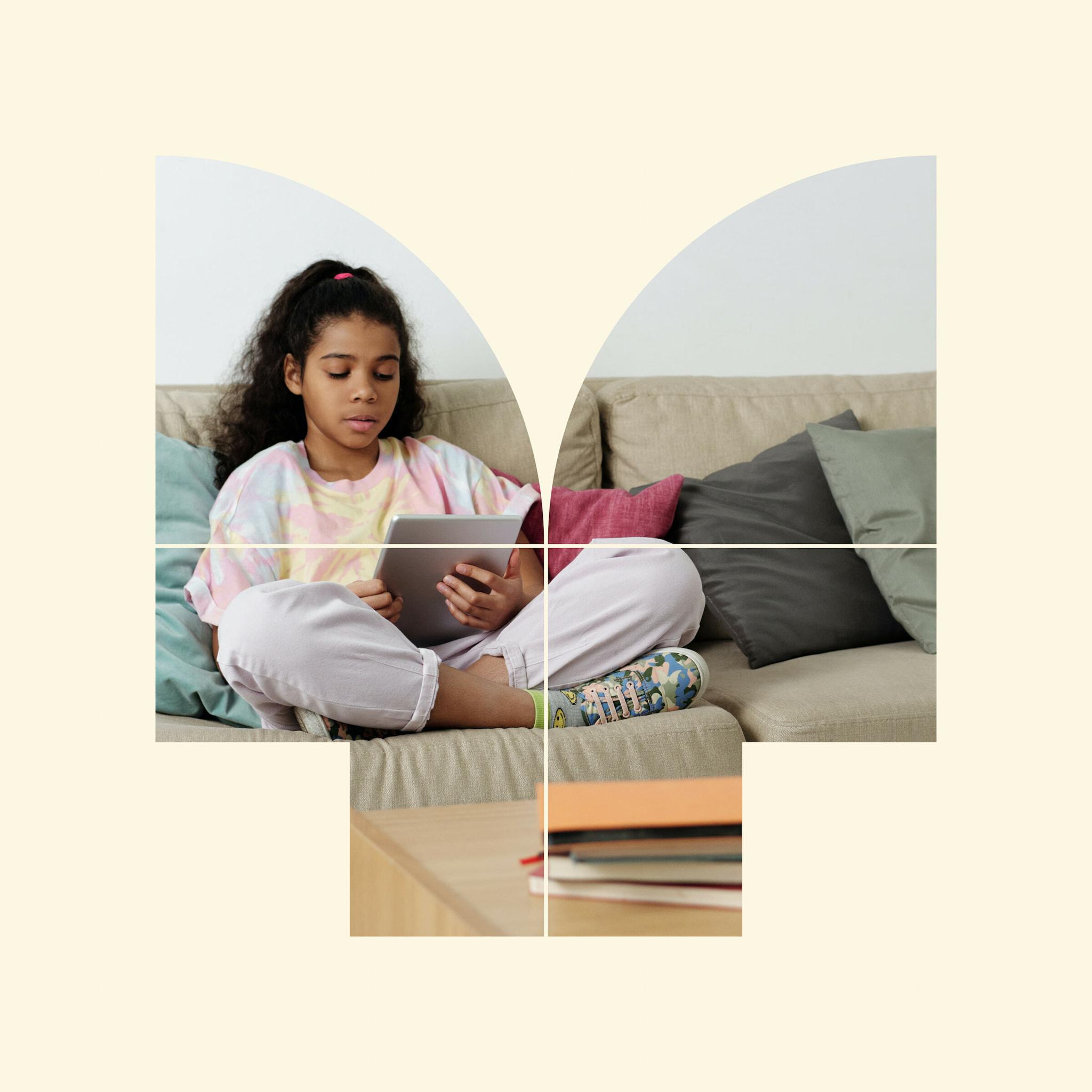 Child sitting on a couch using a tablet, masked by a geometric arch shape