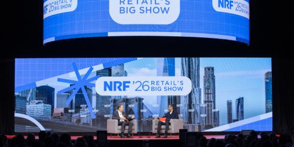 Navigating The Next Now for the retail industry at NRF 2026 in New York City NRF 2026 Retail's Big Show panel discussion on a large stage with city skyline backdrop
